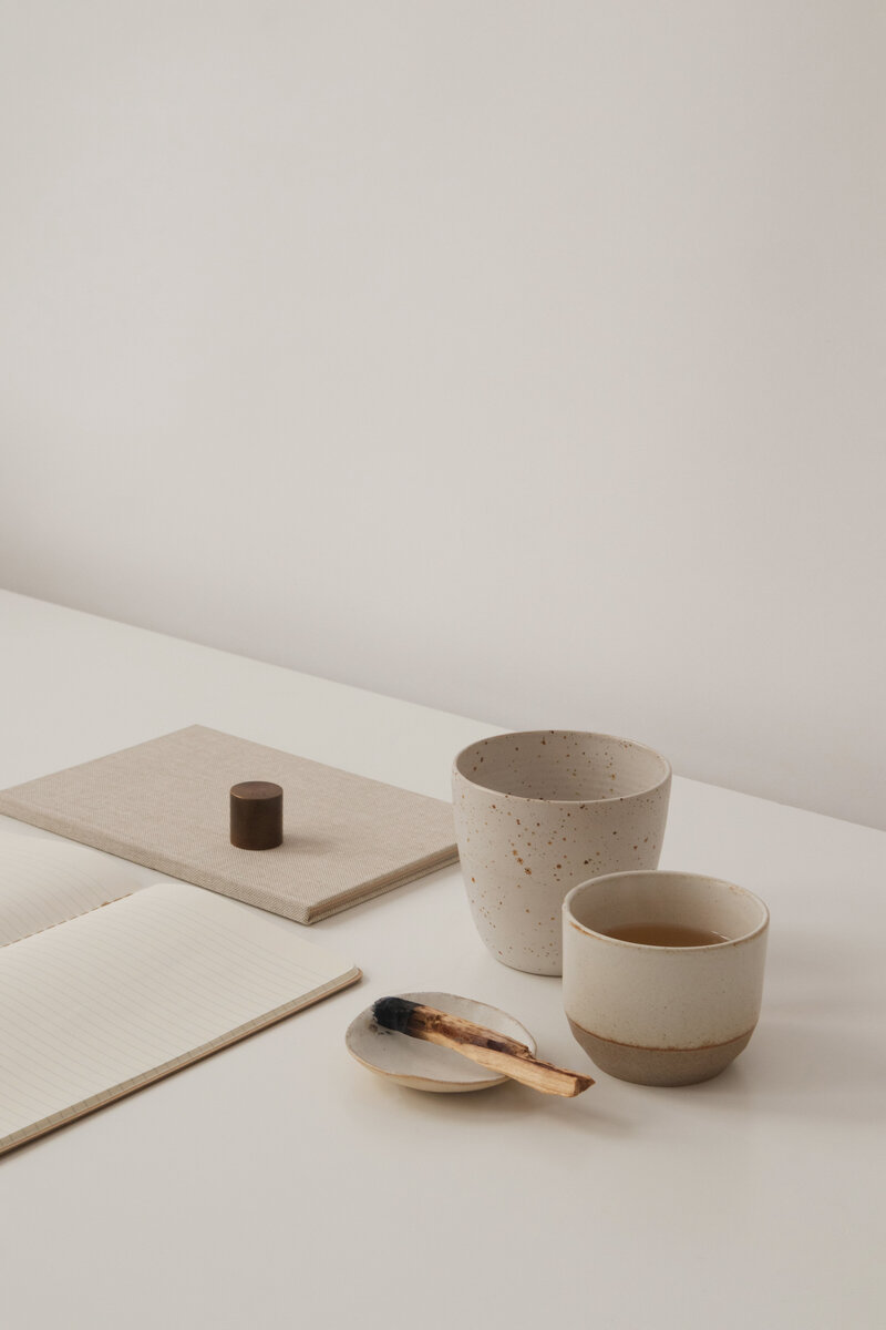 a desk with pottery and burning aromatics on it