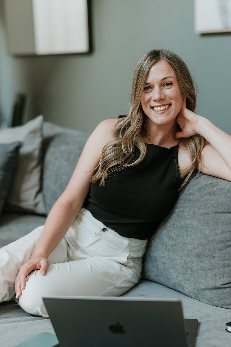Female marketing consultant on couch with work laptop
