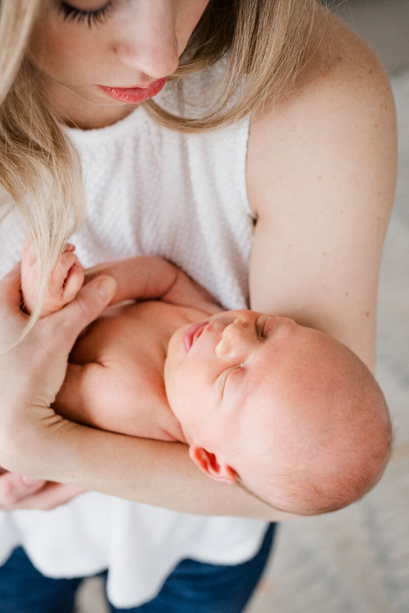 A close-up shot of a mother holding her newborn baby. T