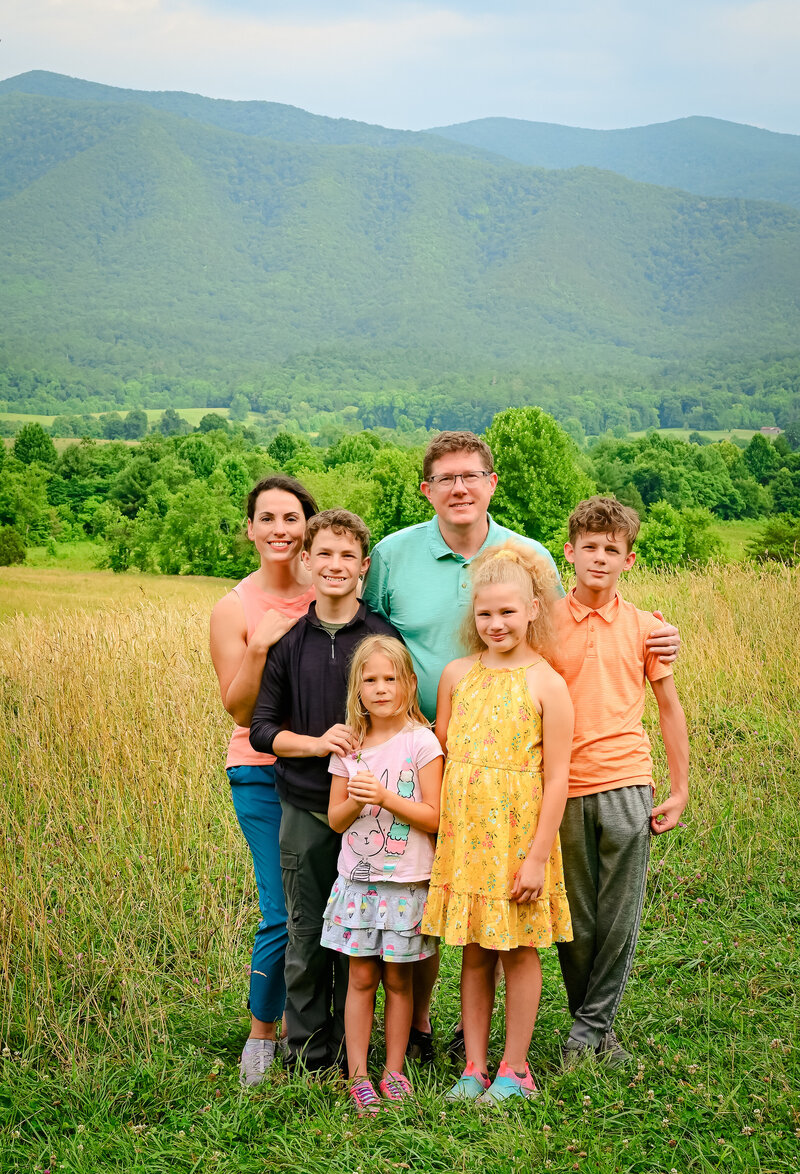 Loving family posing in valley of Great Smokey Mountain National Park.