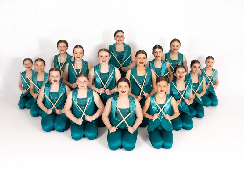 upper elementary girls in their teal costumes posed and ready for thier picture to be taken