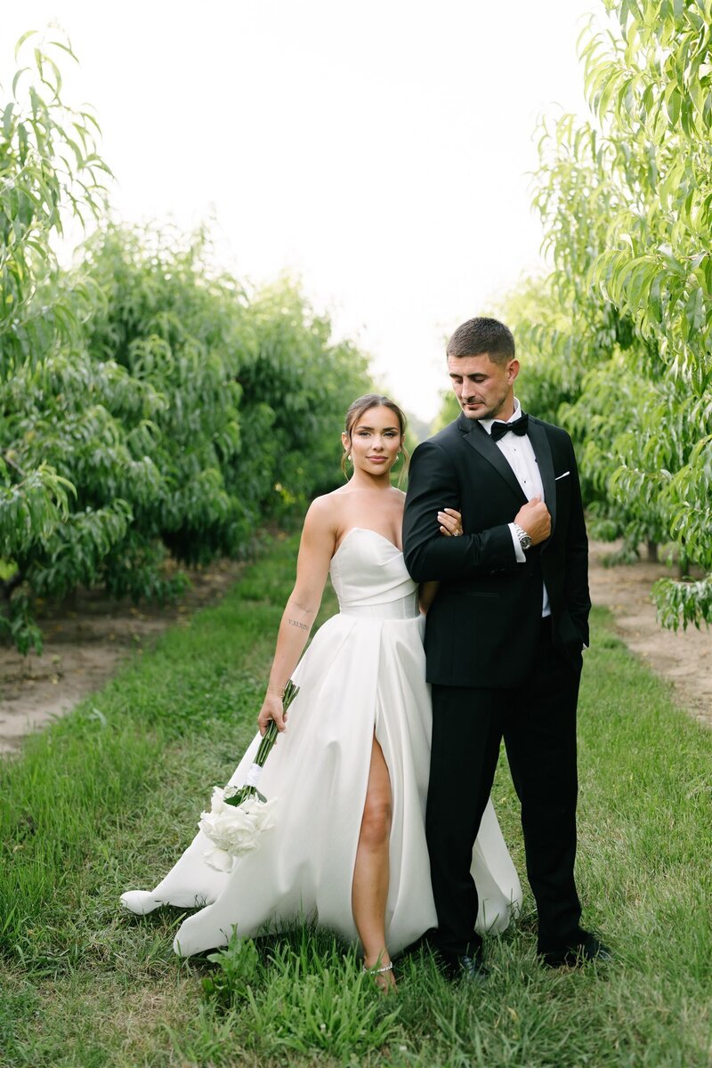 bride and groom standing hand in hand in vineyard