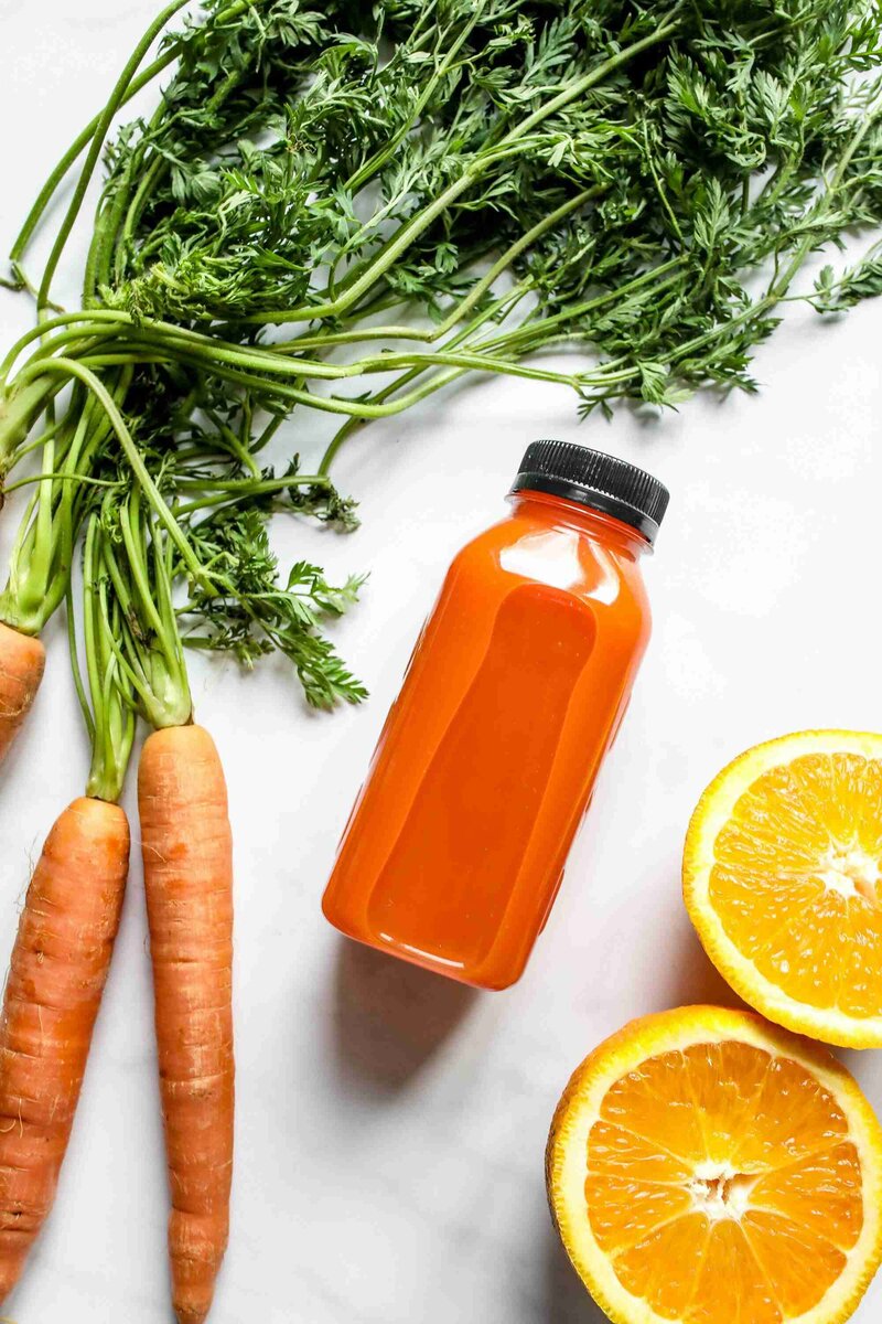 A colorful display of carrots, oranges, and juice, highlighting nutrition tips from Chicago Nutrition Counselor, Megan.