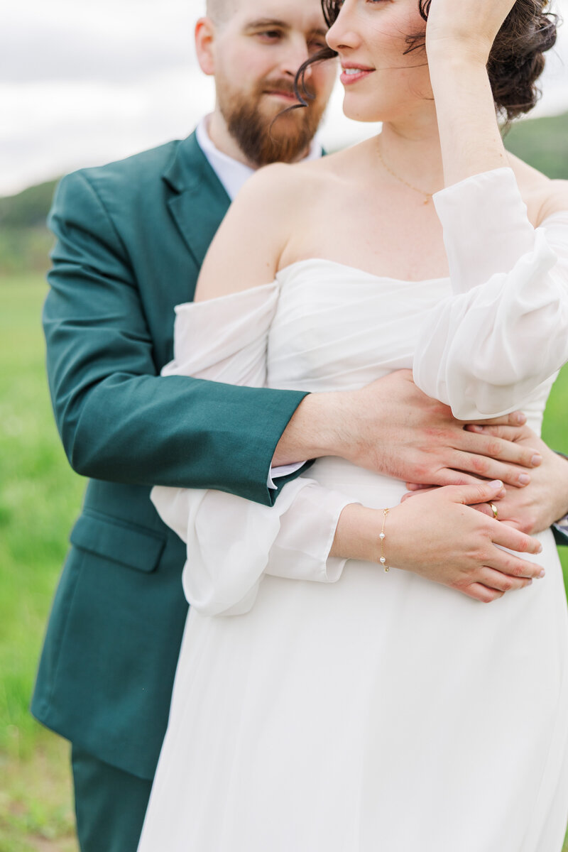 groom embracing bride from behind