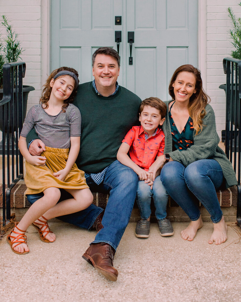 Photographer, Catherine Taylor, sits on her front porch with her husband and two children