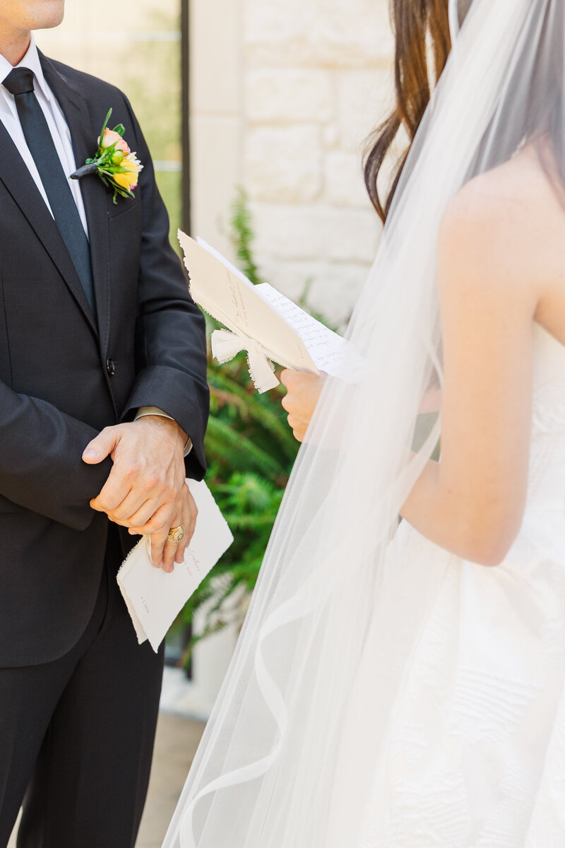 A bride and groom share handwritten vows during a tender outdoor ceremony, symbolizing commitment and faith. This candid moment captures the heart of a Christ-centered marriage celebration. Photographed by a DFW-based wedding photographer specializing in romantic Christian weddings throughout Texas.