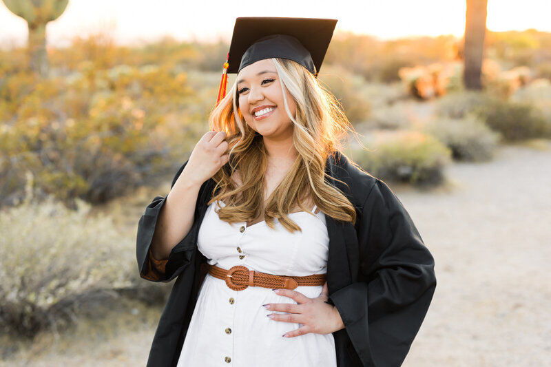 high school senior girl posing for Phoenix senior photographer in graduation cap and gown