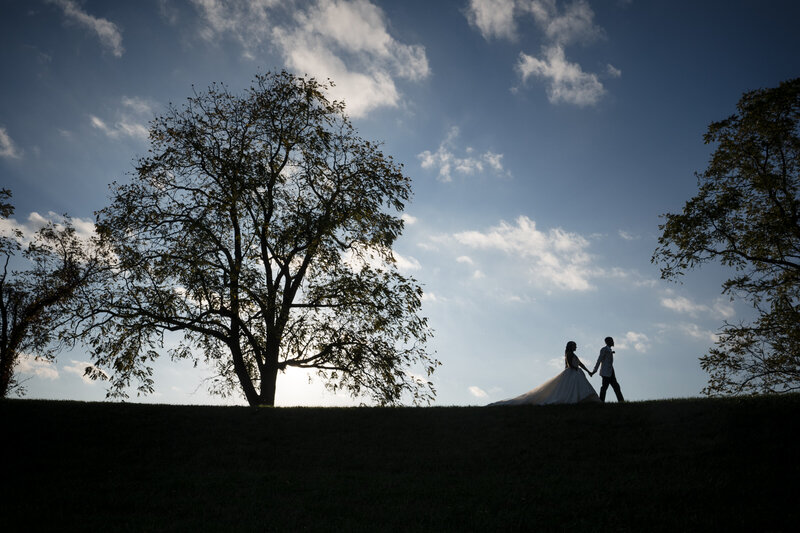 Stunning bride lying in her custom lace wedding gown with crystal detailing, captured in a glamorous bridal portrait at The Crane Bay Event Center in Indianapolis.