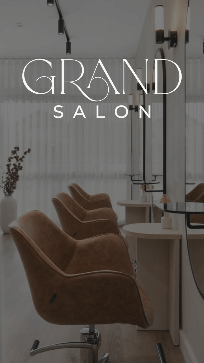 A stylish hair salon interior with brown leather chairs, wall mirrors, and modern lighting—perfect inspiration for a contemporary hair salon website design. “GRAND SALON” is displayed in large white letters at the top of the bright, minimal space.