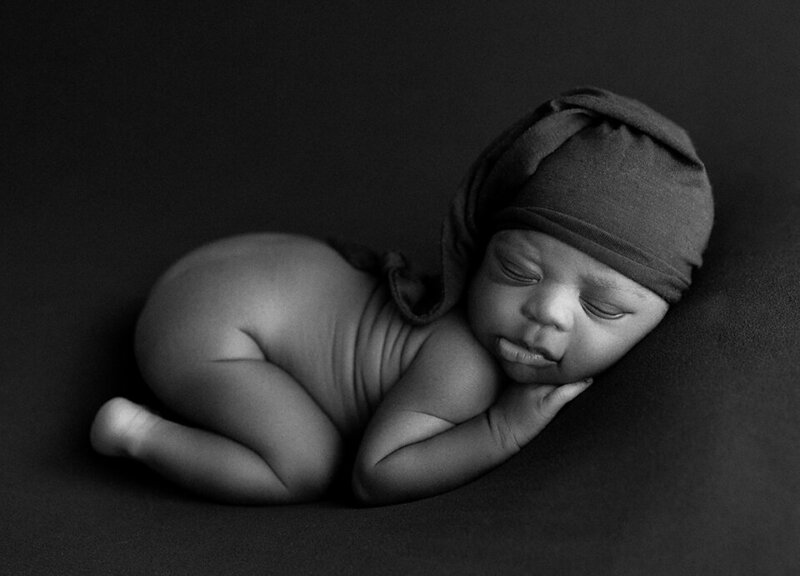 A black and white newborn photo with a sleeping baby in a Coquitlam Photography studio