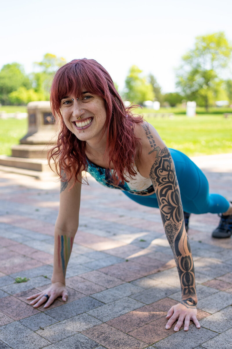 a woman outside does a plank to demonstrate online fitness coaching
