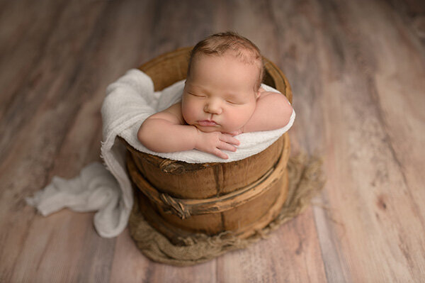 baby posed in a bucket during boston newborn photography session