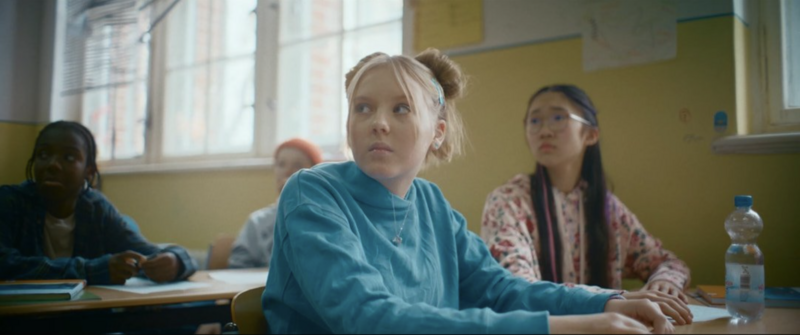 Teens running across a schoolyard in golden hour light, filled with movement and optimism.