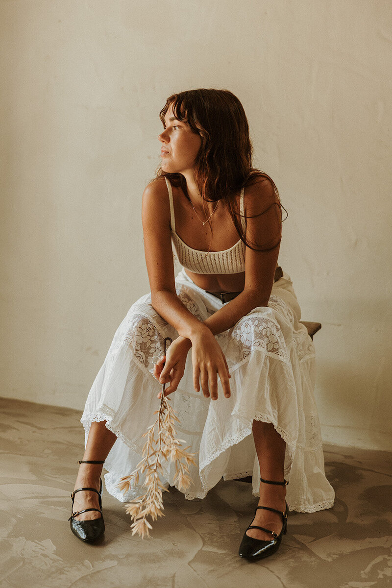 Luxury skincare brand photography featuring a woman applying a facial serum with golden sunlight highlighting her glowing skin. Cinematic and storytelling brand photography for beauty and wellness brands, captured on the Sunshine Coast.