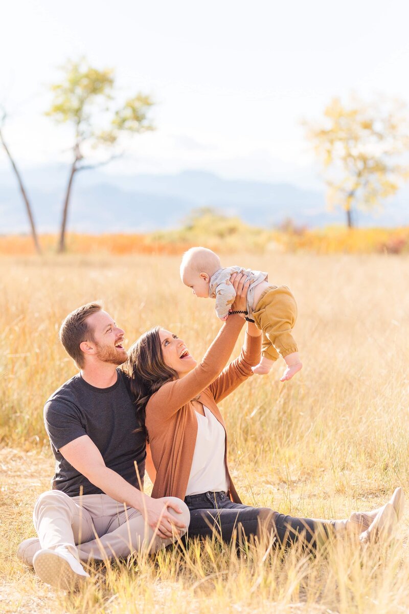 Fall Minis mom holding baby in air McIntosh Lake Longmont Colorado