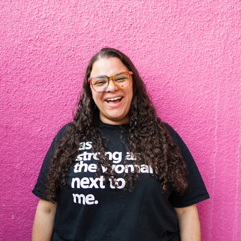 Colie smiles in front of a pink background