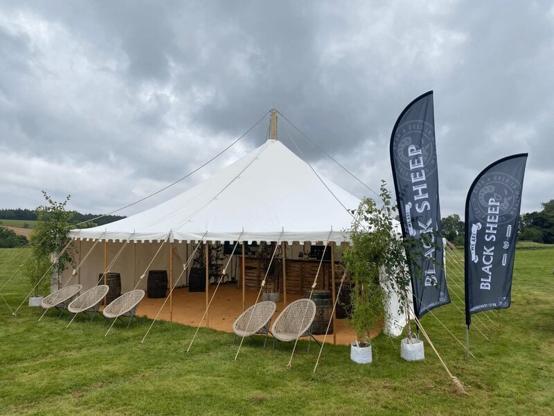 A square pole marquee with seating outside for a pomo event