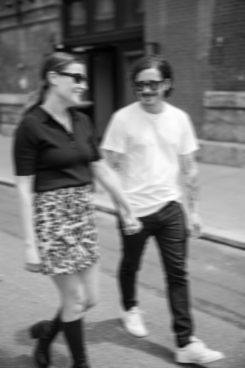 Engaged couple walking hand-in-hand through Philly’s city streets

