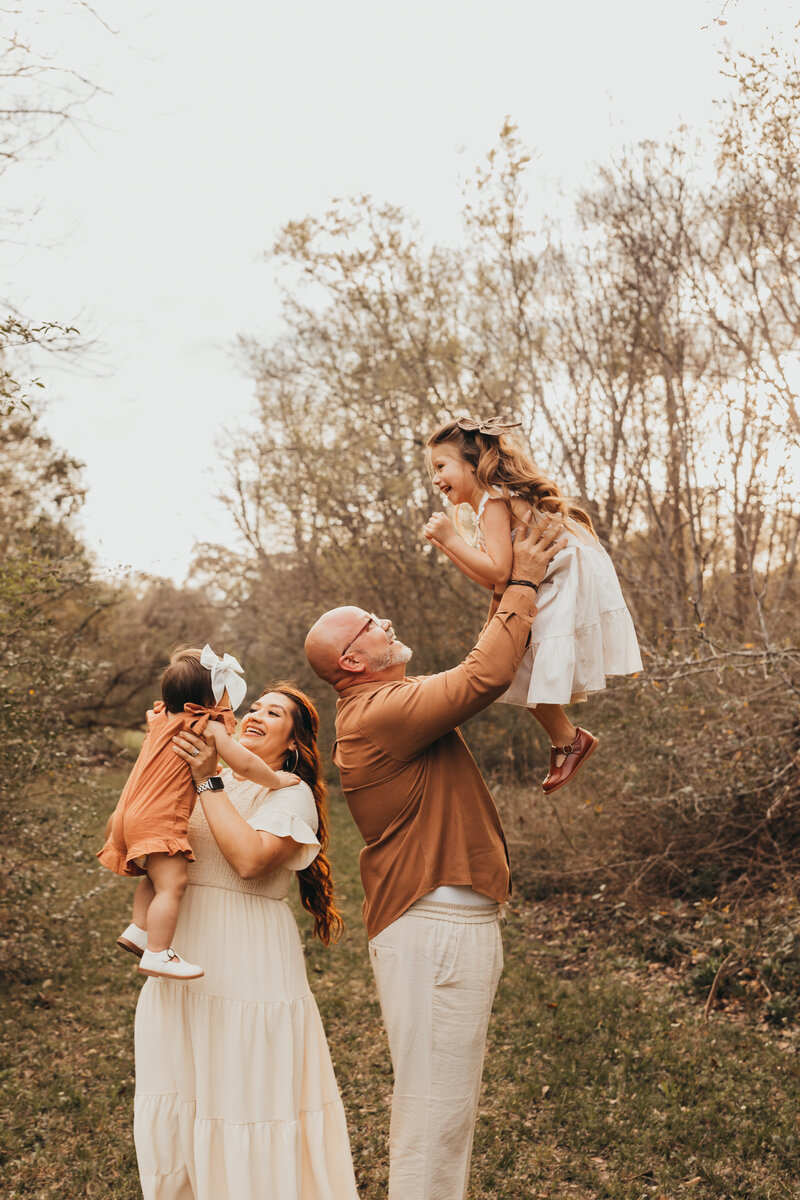 family loves on baby brother in a field family session.