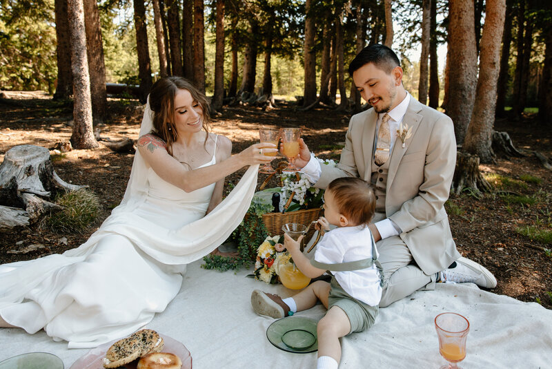 young family enjoys a picnic in the woods after eloping in colorado