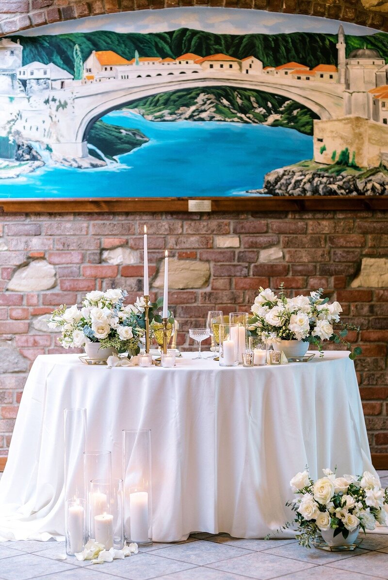 elegant sweetheart table decorated with candle light and floral set in the cemtury room