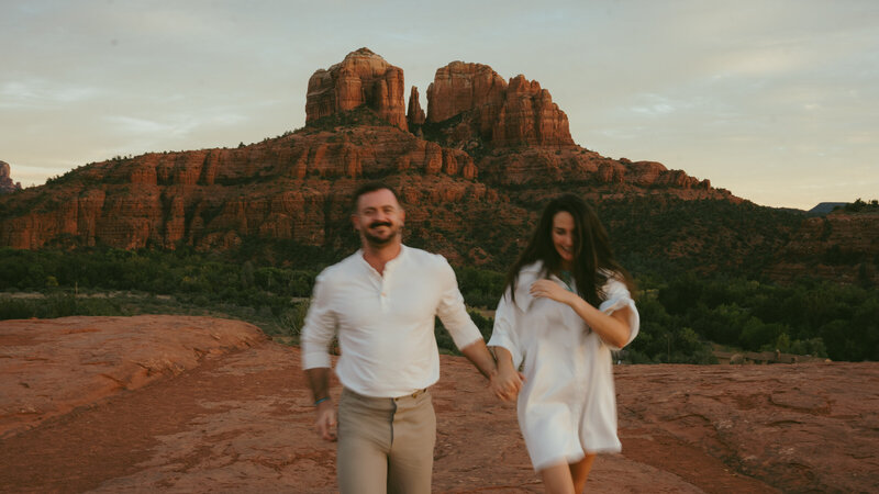 Couple embracing at sunset on a red rock cliff in Sedona during their elopement