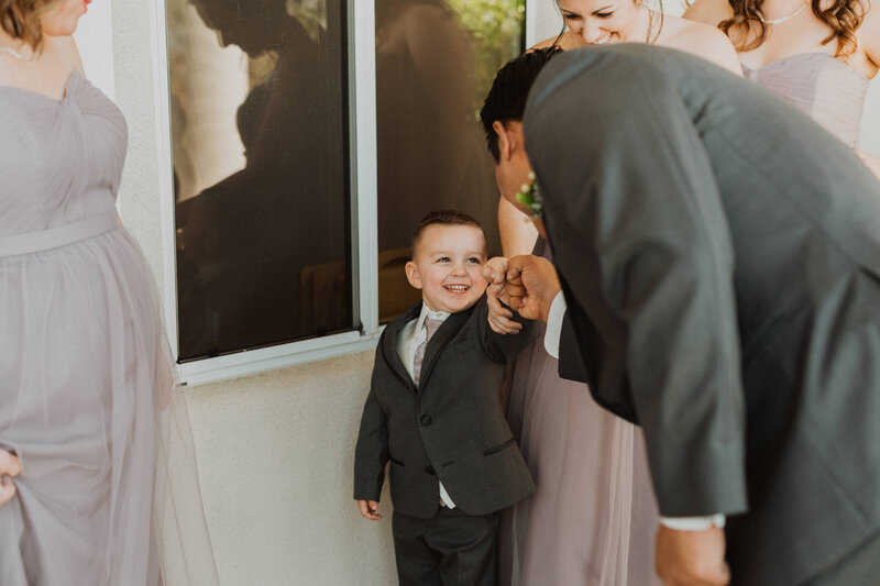 A small child shaking a grooms hand.