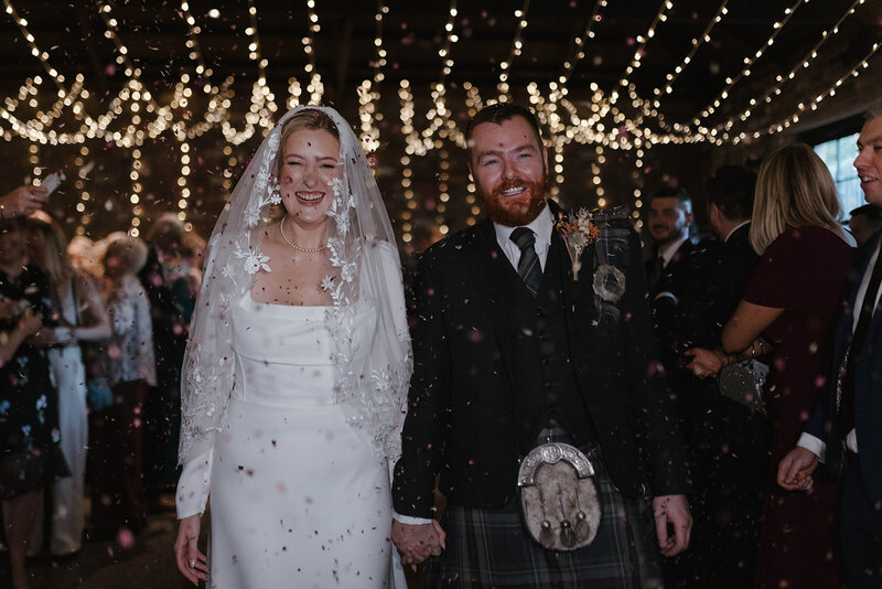 Emotive couples portrait in soft golden backlight during a Scottish outdoor session, with the pair embracing in a cinematic fine art style, photographed by wedding photographer Aly Robinson.”
