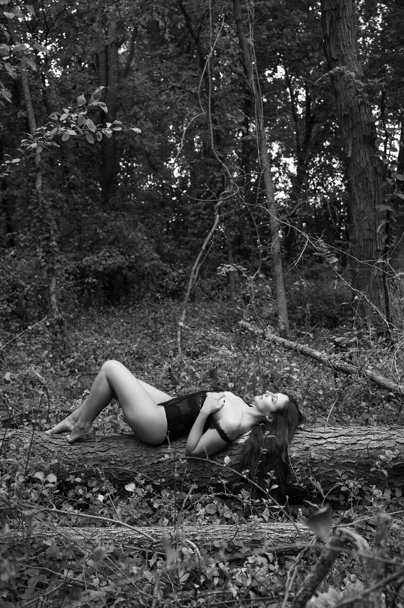 woman laying on log with black lace bodysuit