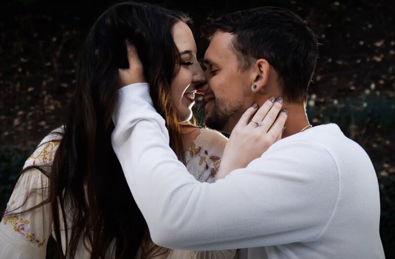 A couple with their arms around each other about to kiss 