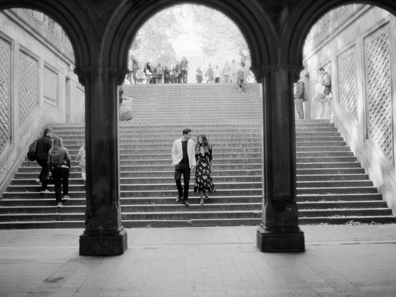 couple walking down the staircase to go under central park bridge