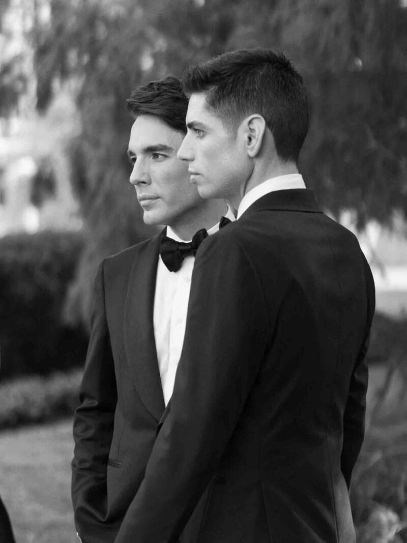 Black-and-white portrait of two grooms in timeless formal attire
