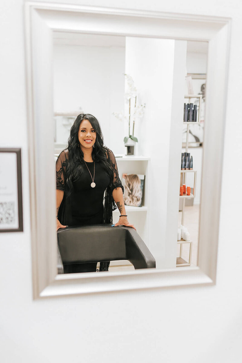 Idelisse smiling standing behind salon chair