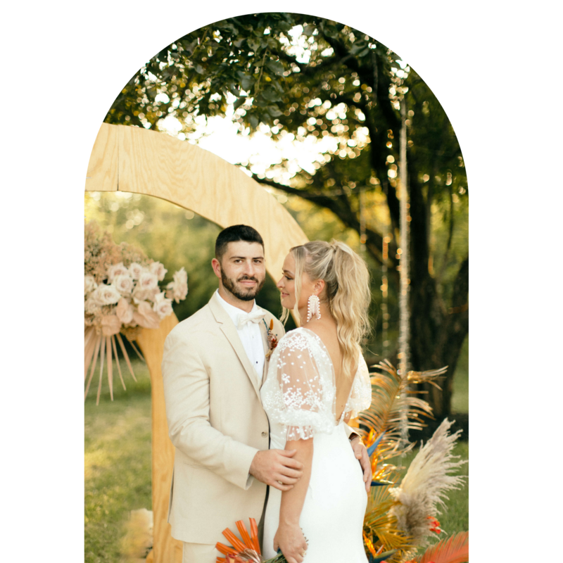 gold brown and yellow wedding boho bride and groom in front of arch