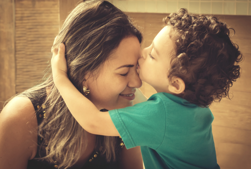 T1D mom receiving a kiss from her young son — symbolizing love, care, and support on the Type 1 Diabetes journey.
