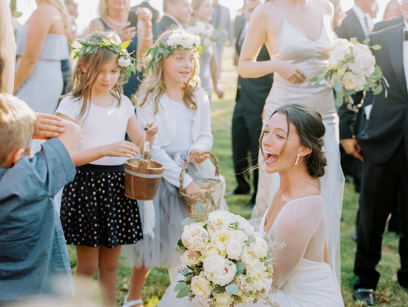 image of bride smiling with flower girls telling them what a great job they did walking down the aisle