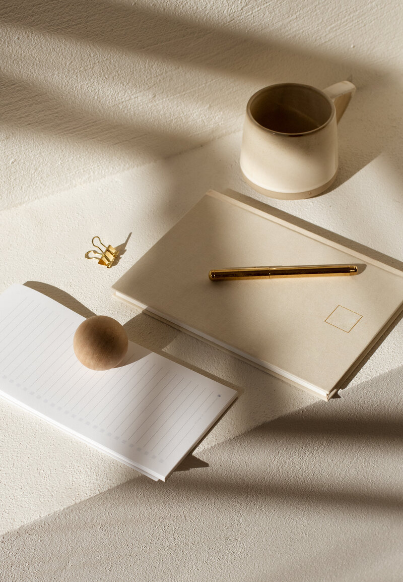 Photograph of stationary on a table in sunlight and beige shades