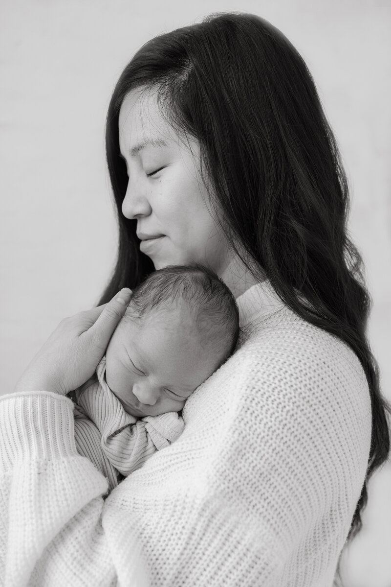 close up of mom and newborn holding each other during a studio session in everett