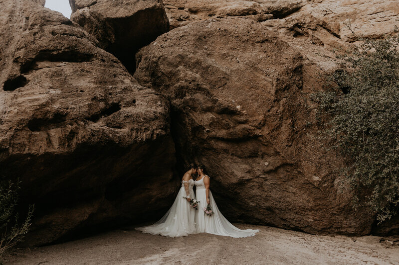 bride and groom standing in front of a lake