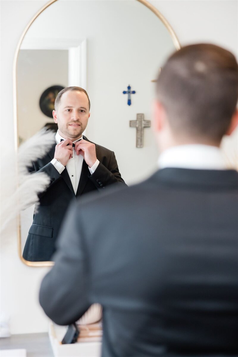 Groom getting ready in a mirror photo by Orlando wedding photographer. 