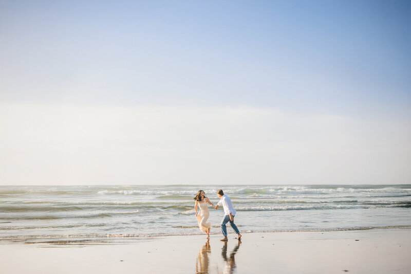 boy and girl running on the oregon coast together