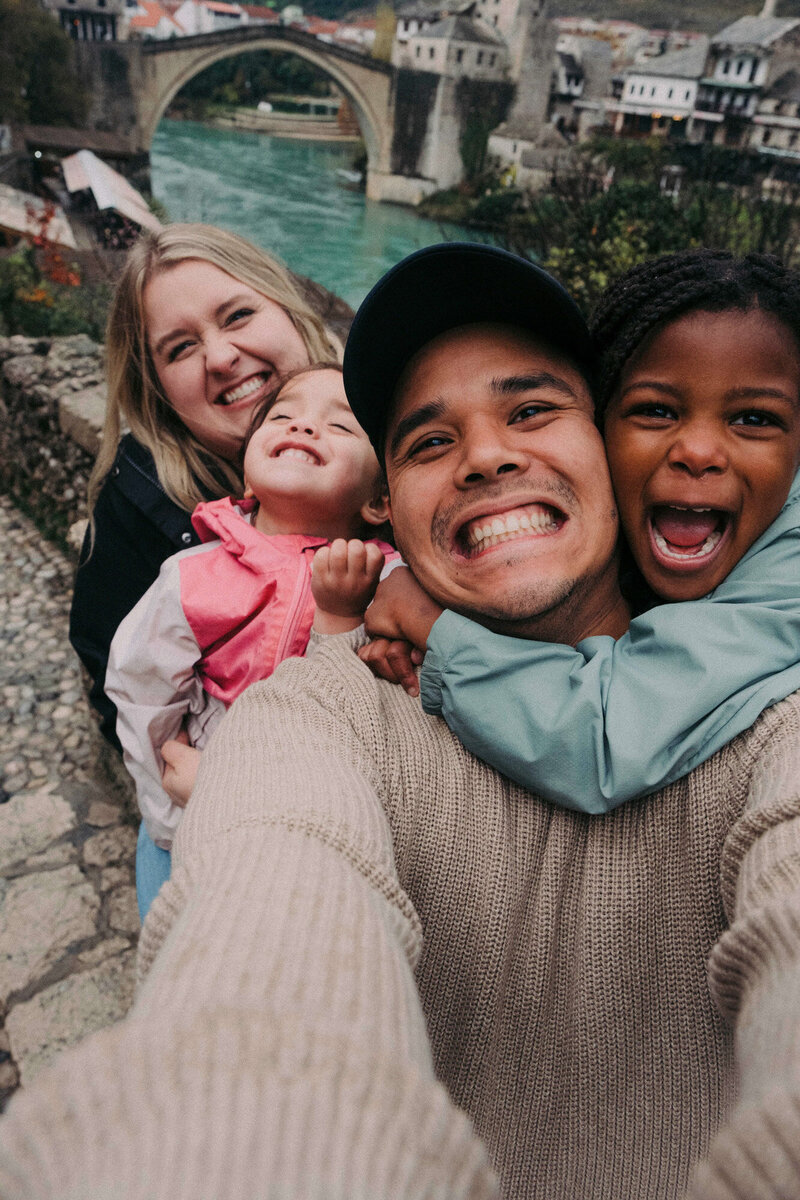 Family of four taking a fun photo while traveling