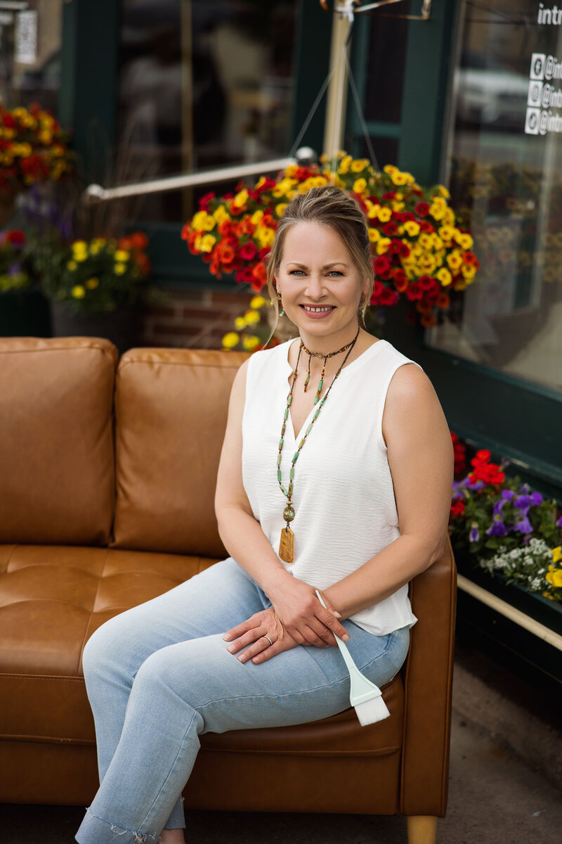 Christine Harris, professional stylist and beauty expert at Intrigue Salon, seated in the salon’s cozy waiting area