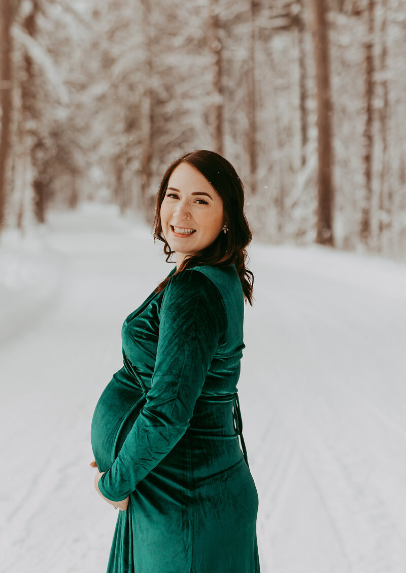woman-in-snow-holding-pregnant-belly
