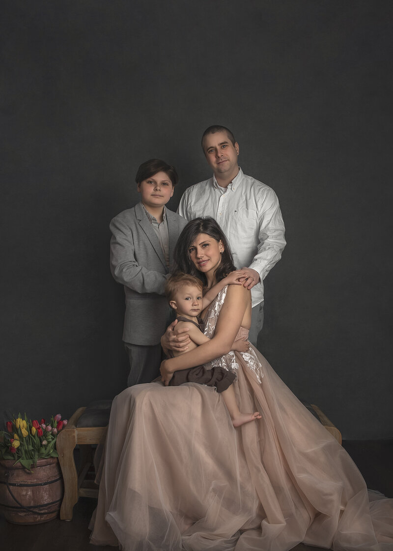  "A timeless and elegant classic family portrait session, capturing the love and unity of your family in a sophisticated studio setting in Ottawa."