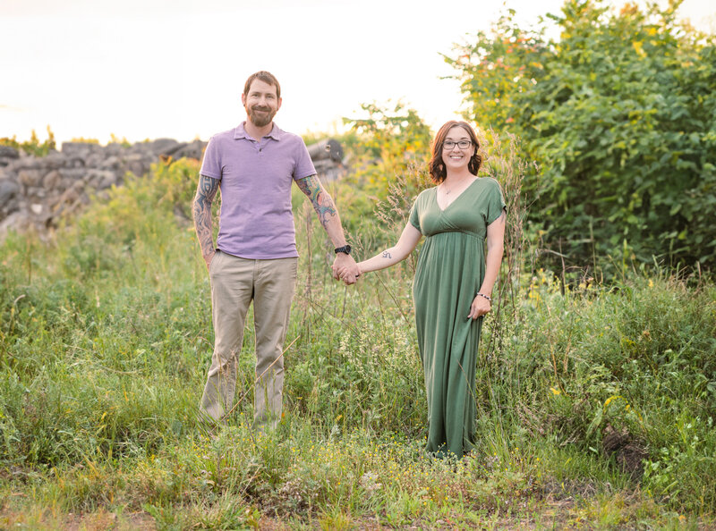 York PA photographer and her husband posing in tall grass during golden hour