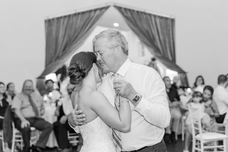 Heartwarming moment of a bride sharing a first dance with her father at The Manor House in Littleton, Colorado, capturing the emotional bond and joy of their special day.
