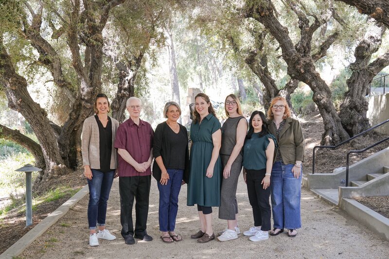 The Imagining Worship with Kids team standing outdoors beneath oak trees at Fuller Seminary’s Brehm Center, representing their collaborative ministry for creative worship with children.