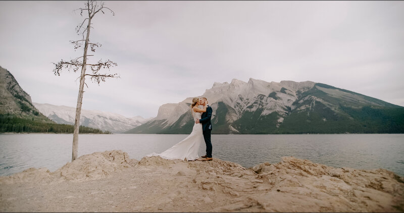 Couple walking across a field in Canmore AB on their wedding day at silvertip resort