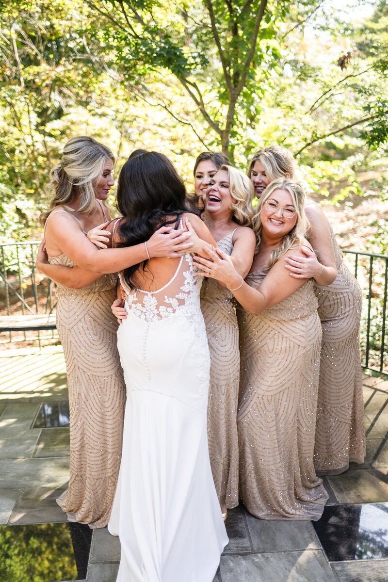 Bride hugging bridesmaids